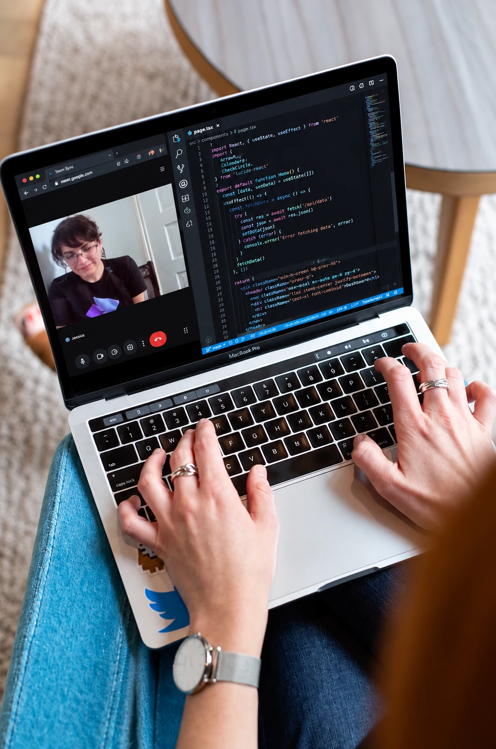 A pair of hands typing on a laptop during a video call with a colleague